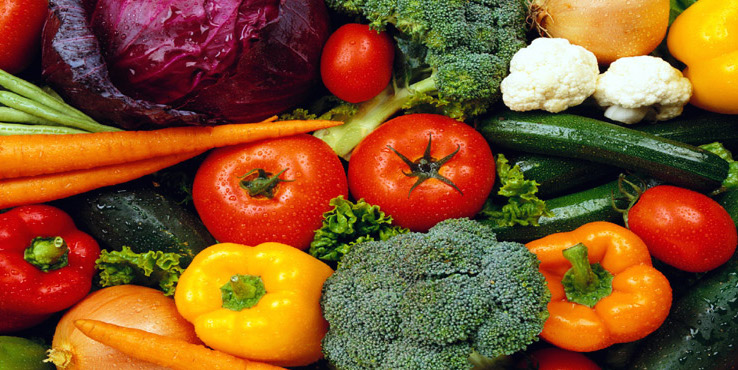 Tomatoes, broccoli, carrots and other vegetables hang out together in a bunch.