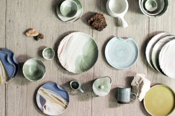 Handmade colourful dinnerware laid out on a table