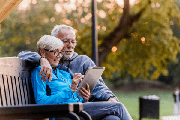 Couple sitting on porch looking at iPad